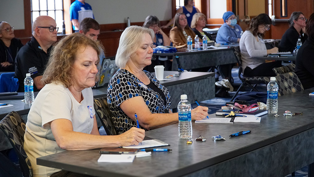 Blue Partner Network team members take notes during the kick off meeting