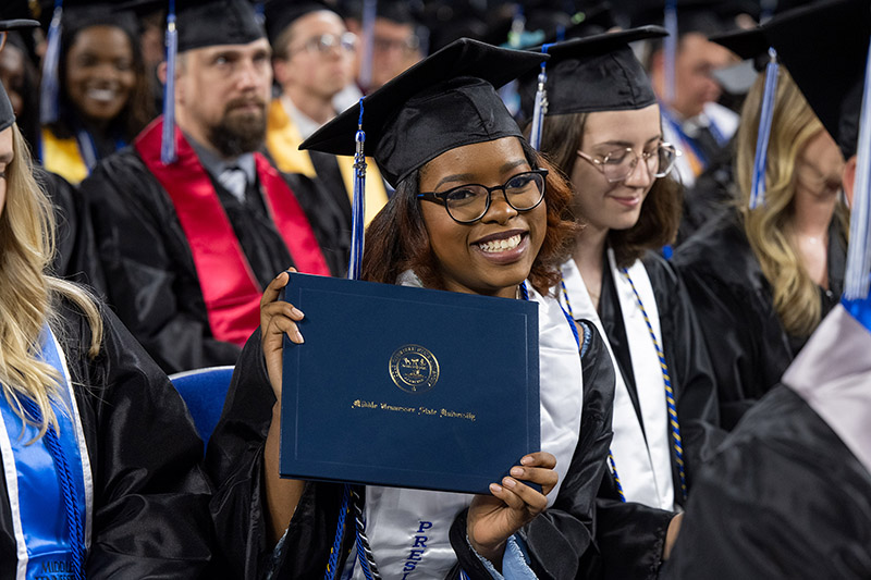 graduate holding diploma