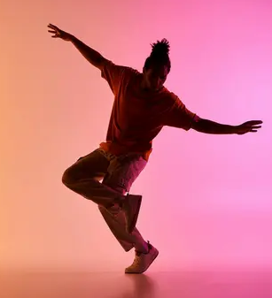 A woman dancing against a deep pink and orange backdrop; it evokes movement