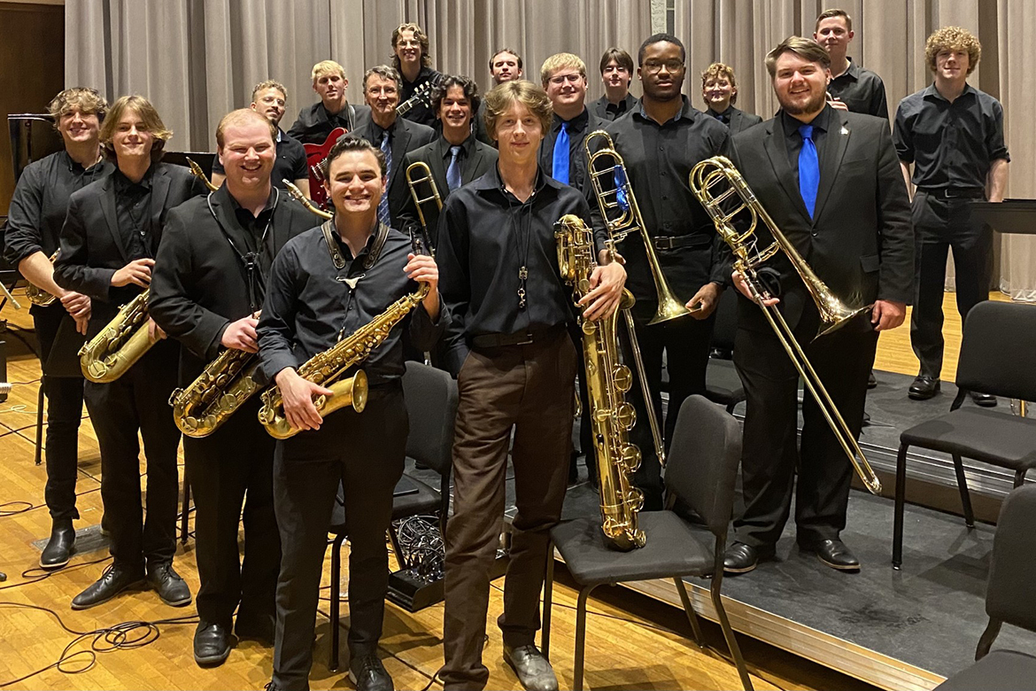 Jazz ensemble students pose for a group photo with their instruments.