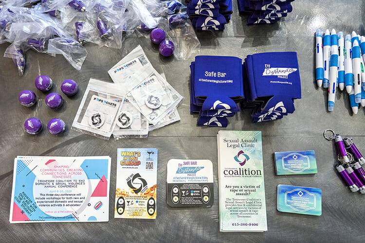 Items promoting personal safety are shown awaiting distribution at the 2018 MTSU Safety Summit March 22. The second and third items on the bottom row are coasters that can be used to test for the presence of drugs in a bar patron’s drink. (MTSU photo by J. Intintoli)