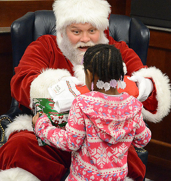 Santa Claus (aka Rich Kershaw, director of MTSU Student Programming) presents gifts to an excited Little Raider at this year’s annual Christmas Party. (MTSU photo by Jimmy Hart)