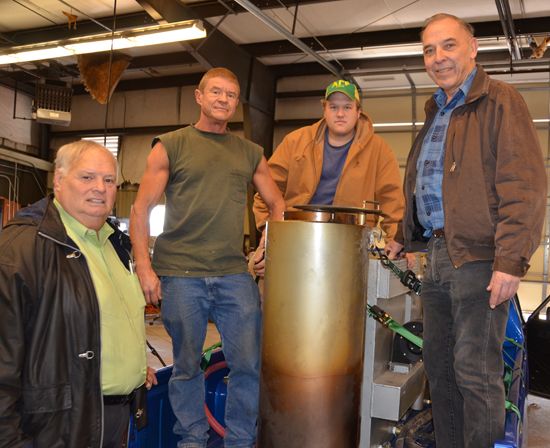 Shown with the wood gasification unit used in the research project, Cliff Ricketts, left, stands with crew members Terry Young, MTSU senior Colton Huckabee and Mike Sims. (MTSU photo by Randy Weiler)