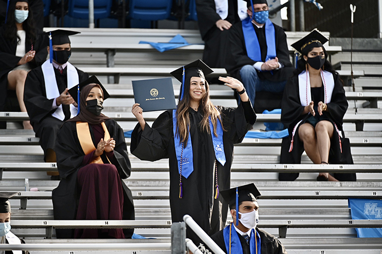 An MTSU student waves as she's recognized on the Jumbotron at Floyd Stadium during the university's fall 2020 commencement ceremonies last November. MTSU, which held virtual graduations for its May and August 2020 graduates because of the pandemic, held three outdoor events last fall. Spring 2021 graduates will return to Murphy Center May 7-9 for the first time since 2019 for a three-day, 10-event, socially distanced commencement weekend. (MTSU file photo by J. Intintoli)