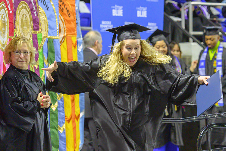 An excited MTSU graduate leaves the Murphy Center stage after receiving her degree in this December 2019 file photo, during what became the university's last in-person commencement ceremony before the pandemic hit. MTSU plans its first in-person commencement ceremonies for 2020 this Saturday, Nov. 21, to celebrate the accomplishments of the December 2020 graduates. May and June 2020 graduates will also be honored in person during the day's events. (MTSU file photo by Cat Curtis Murphy)