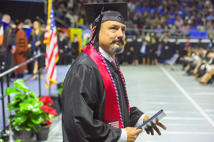 A new MTSU graduate looks toward his supporters in the Murphy Center crowd after receiving his degree in this December 2019 file photo, during what became the university's last in-person commencement ceremony before the pandemic hit. MTSU plans its first in-person commencement ceremonies for 2020 this Saturday, Nov. 21, to celebrate the accomplishments of the December 2020 graduates. May and June 2020 graduates will also be honored in person during the day's events. (MTSU file photo by Cat Curtis Murphy)