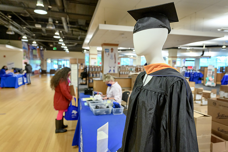 A mannequin displays the latest fashion for graduates of the MTSU School of Nursing master's program inside Phillips Bookstore Monday, May 3, as graduating students pick up their caps, gowns and other items in the background. MTSU's spring 2021 graduates are returning to Murphy Center May 7-9 for the first time since 2019 for a three-day, 10-event, socially distanced commencement weekend. (MTSU photo by J. Intintoli)