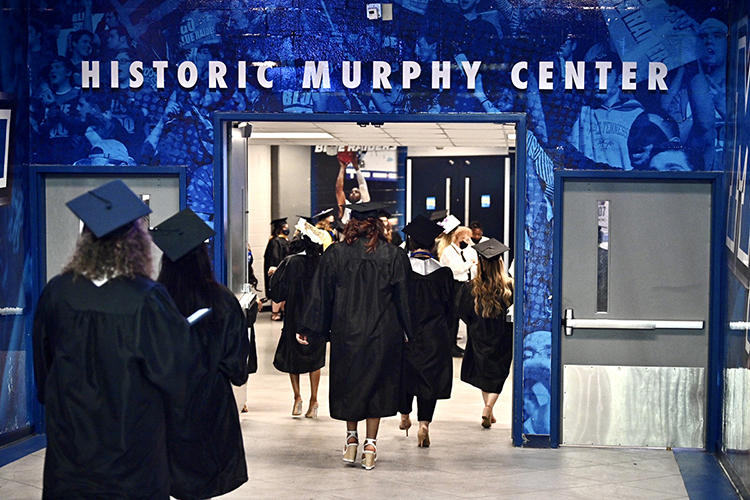 Members of MTSU's first Class of 2021 walk down a hallway under Murphy Center to take their seats in Hale Arena before one of the three spring 2021 commencement ceremonies held Friday, May 7, inside the facility. Graduates and their guests returned to Murphy Center May 7-9 for the first time since 2019 for a three-day, 10-event, socially distanced commencement weekend. (MTSU photo by J. Intintoli)
