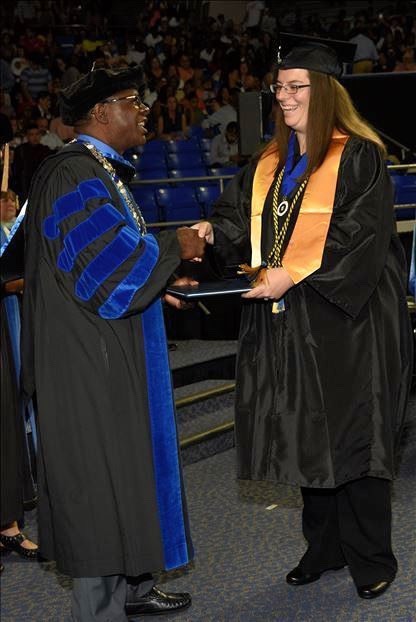 Ashley Pearson receives her bachelors degree from president sydney mcphee