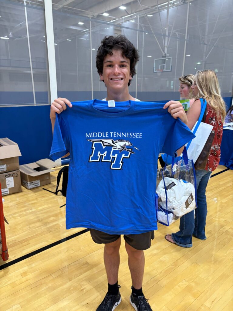 student posing with an MTSU t-shirt