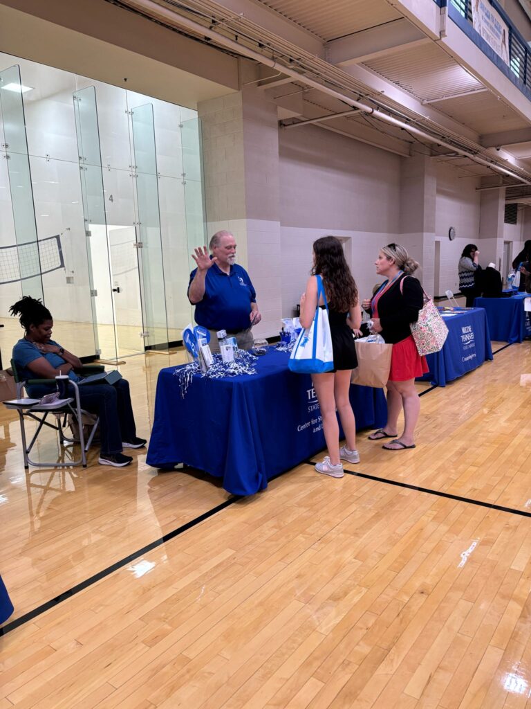 students talking to staff at a tabling event