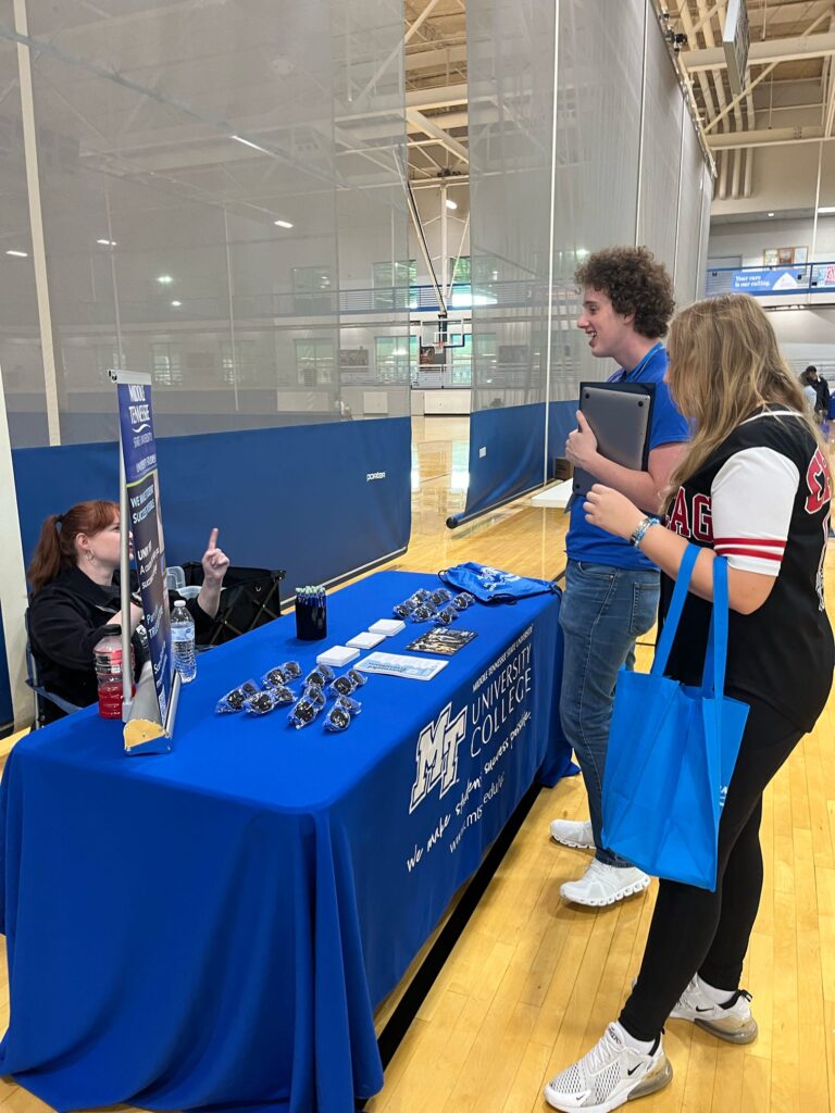 students talking to staff at a tabling event