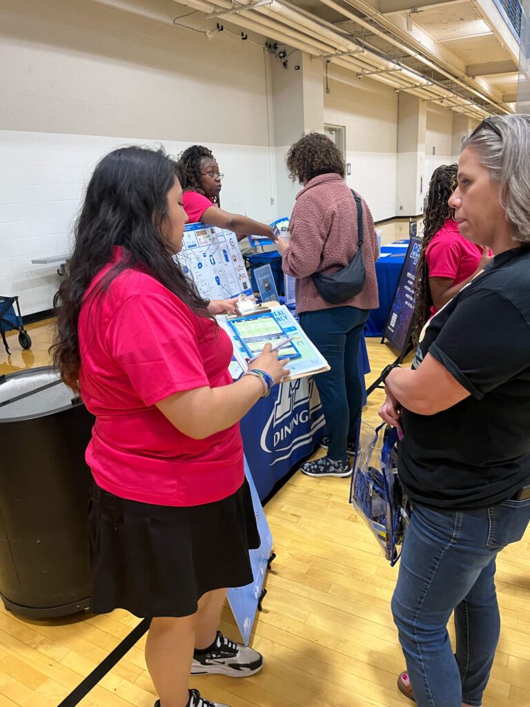 students talking to staff at a tabling event