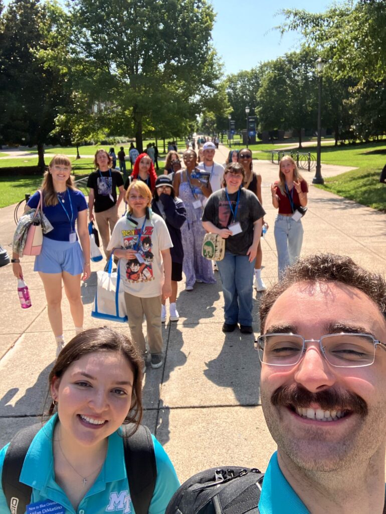 Group of students outside taking a selfie with their Student Orientation Assistants.