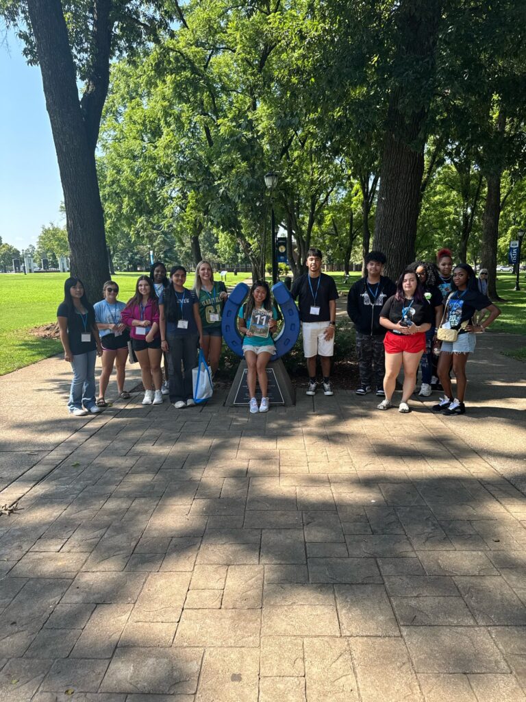 Students standing around the blue horseshoe in Walnut Grove with their Student Orientation Assistant.