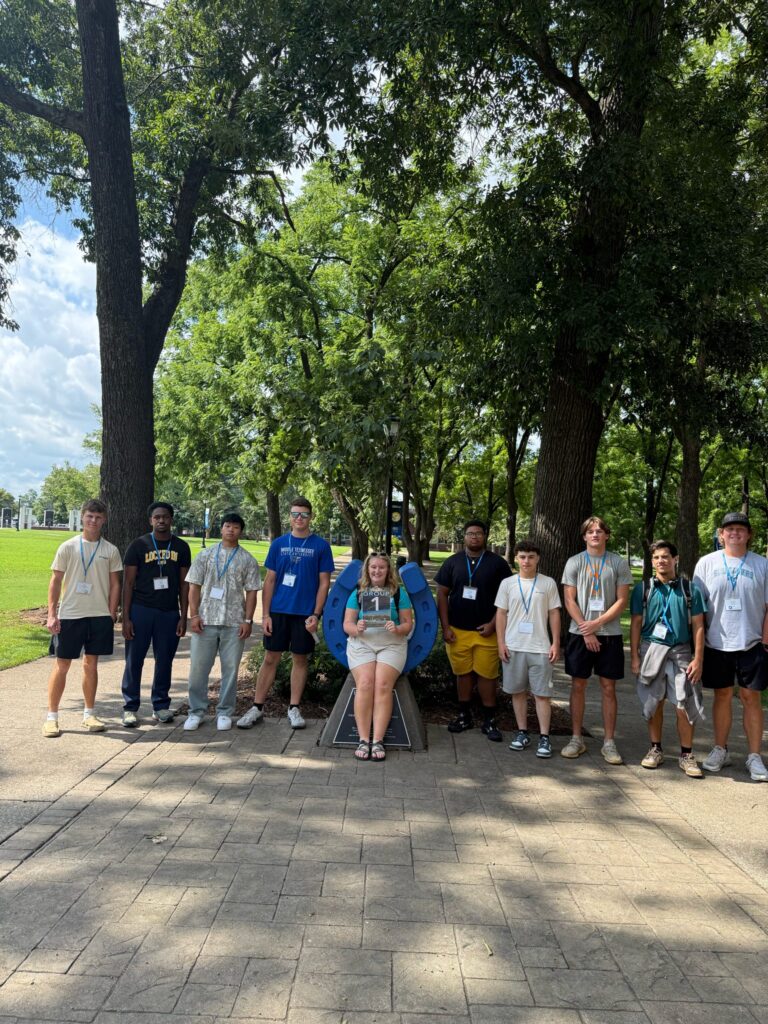 Students standing beside the blue horseshoe at Walnut Grove with their Student Orientation Assistant.