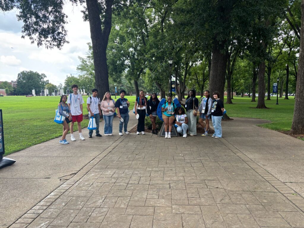 Students standing beside the blue horseshoe at Walnut Grove with their Student Orientation Assistant.