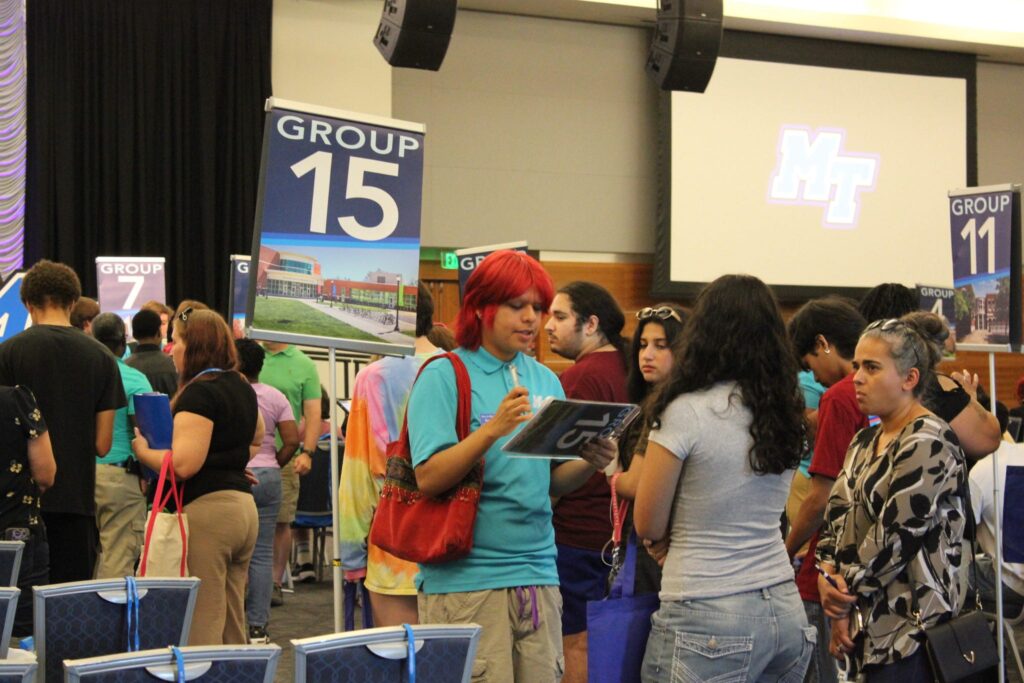 Students checking in to orientation by their Student Orientation Assistant in the Student Union ballroom.