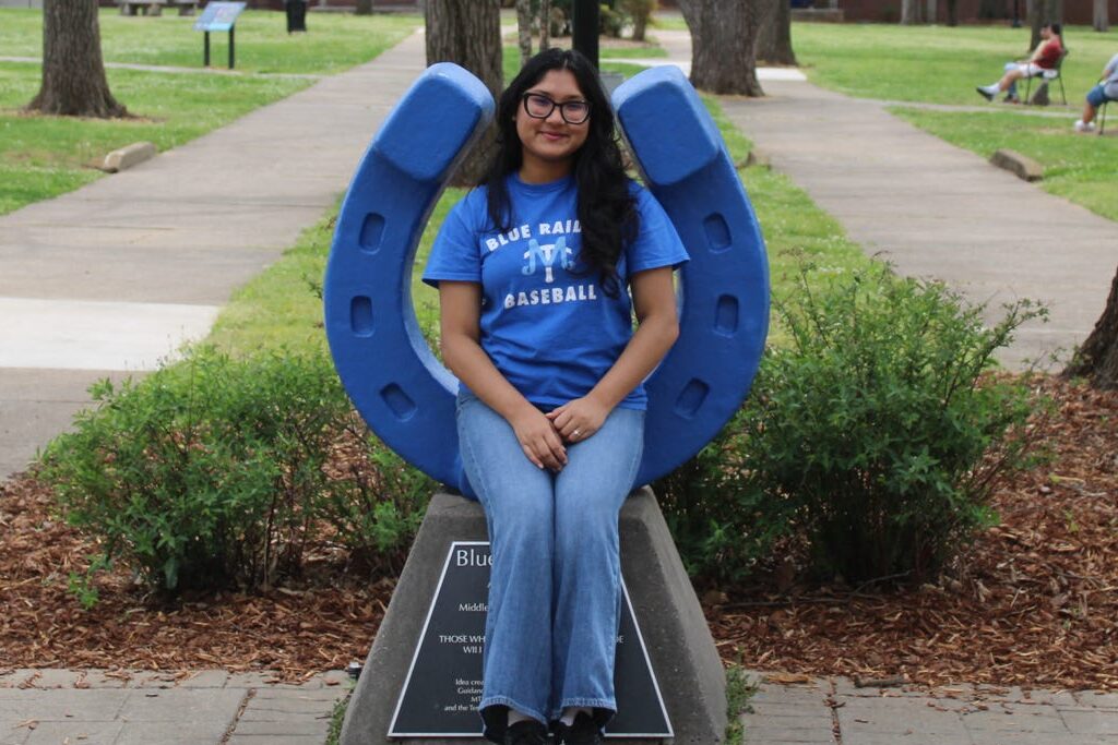 Photo of Ab e Zannat sitting on the blue horseshoe in Walnut Grove at MTSU.