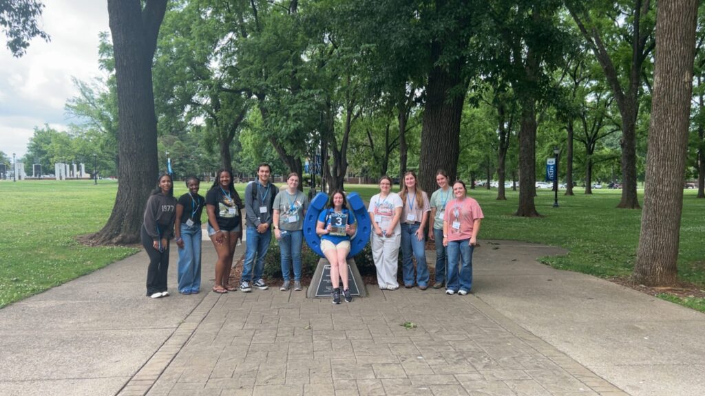 Students in Group 3 of orientation posing for a photo at the blue horseshoe at MTSU with their Student Orientation Assistant.