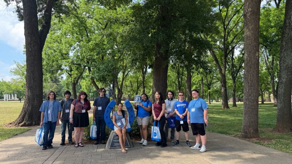 Students in Group 31 of orientation posing for a photo at the blue horseshoe at MTSU with their Student Orientation Assistant.