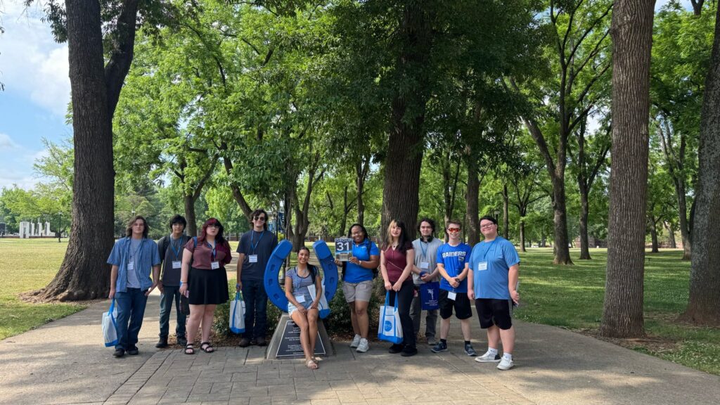 Students in Group 31 of orientation posing for a photo at the blue horseshoe at MTSU with their Student Orientation Assistant.
