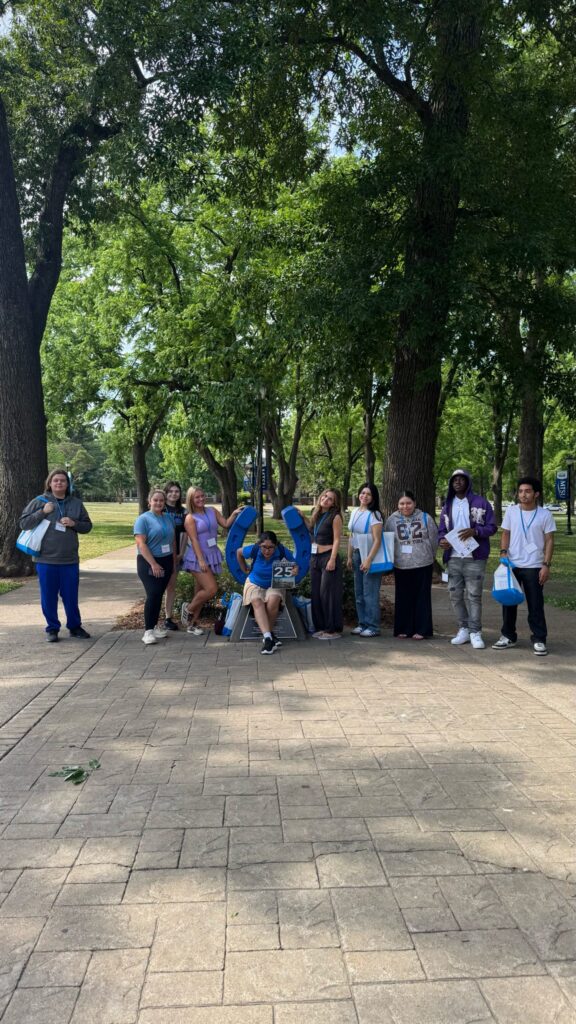 Students in Group 25 of orientation posing for a photo at the blue horseshoe at MTSU with their Student Orientation Assistant.
