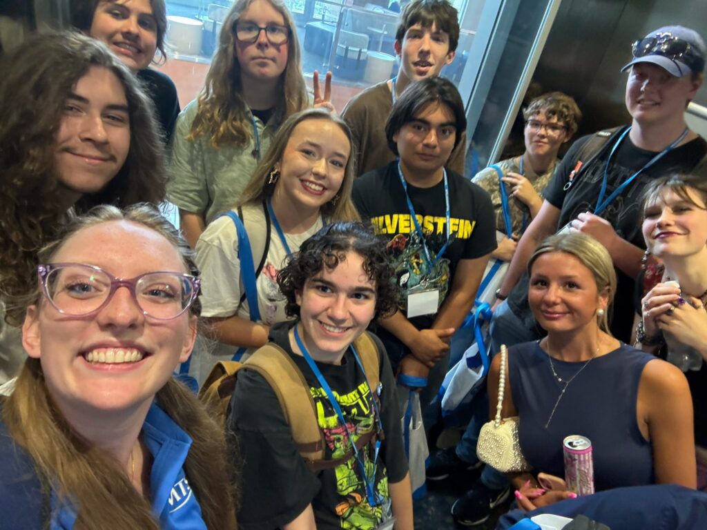 A group of students attending New to Blue Orientation posing for a photo with their Student Orientation Assistant in an elevator in the Student Union.