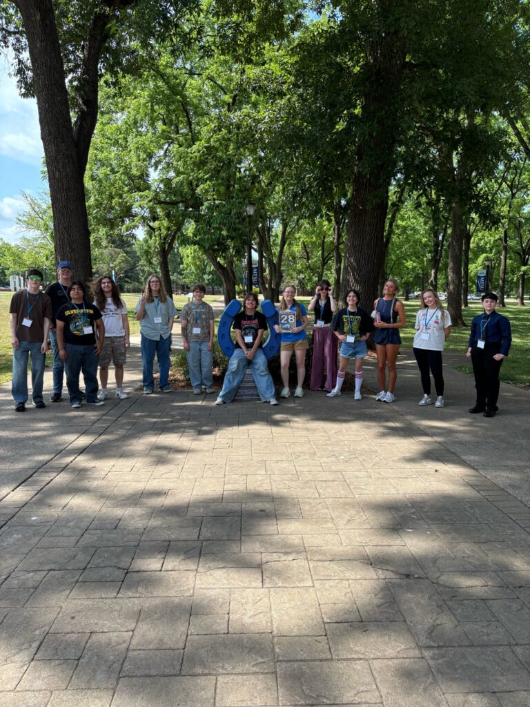 Students in Group 28 of orientation posing for a photo at the blue horseshoe at MTSU with their Student Orientation Assistant.