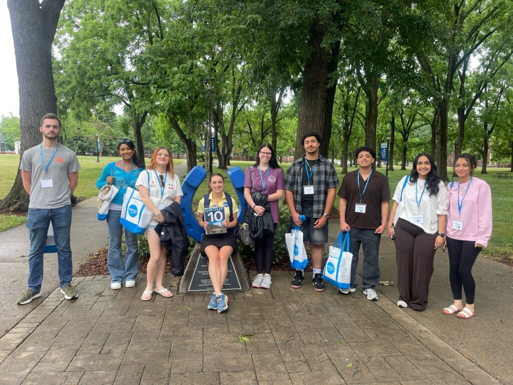 Students in Group 10 of orientation posing for a photo at the blue horseshoe at MTSU with their Student Orientation Assistant.