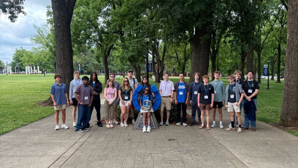 Students in Group 1 of orientation posing for a photo at the blue horseshoe at MTSU with their Student Orientation Assistant.