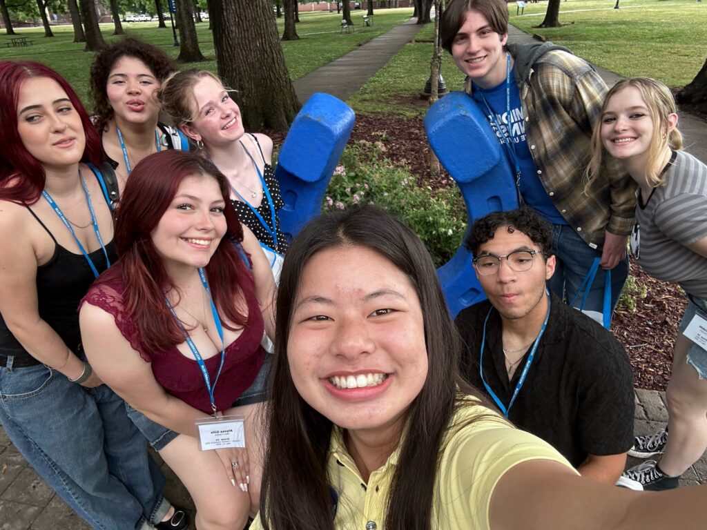 Students attending orientation posing for a photo at the blue horseshoe at MTSU with their Student Orientation Assistant.