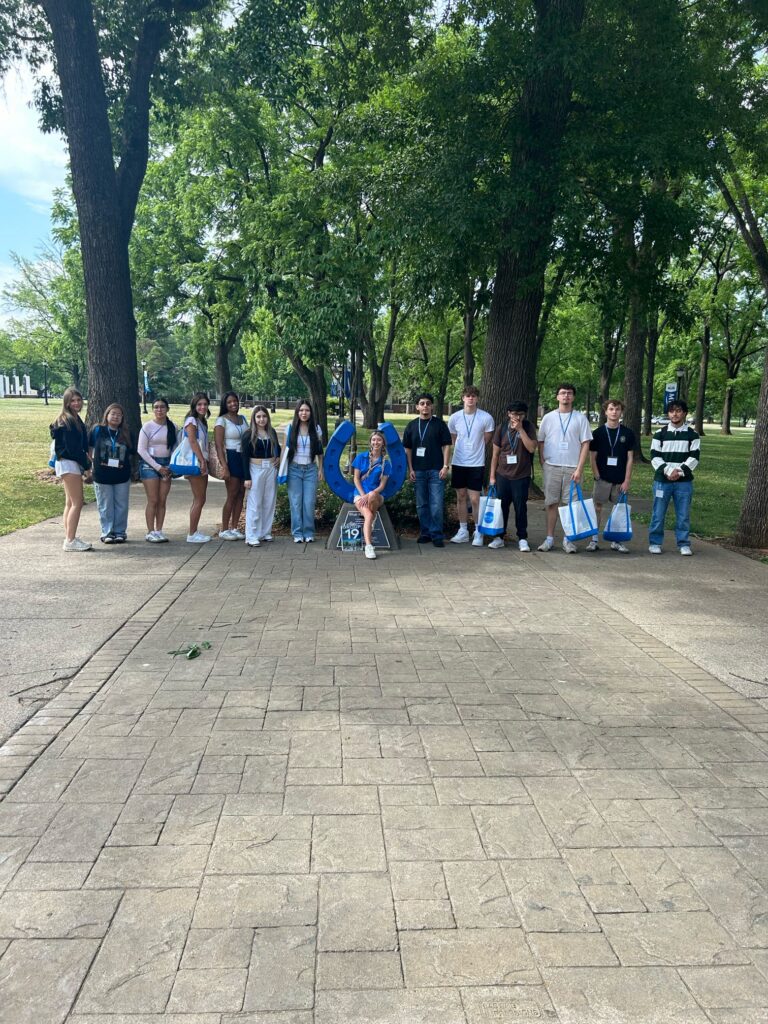 Students in Group 19 of orientation posing for a photo at the blue horseshoe at MTSU with their Student Orientation Assistant.