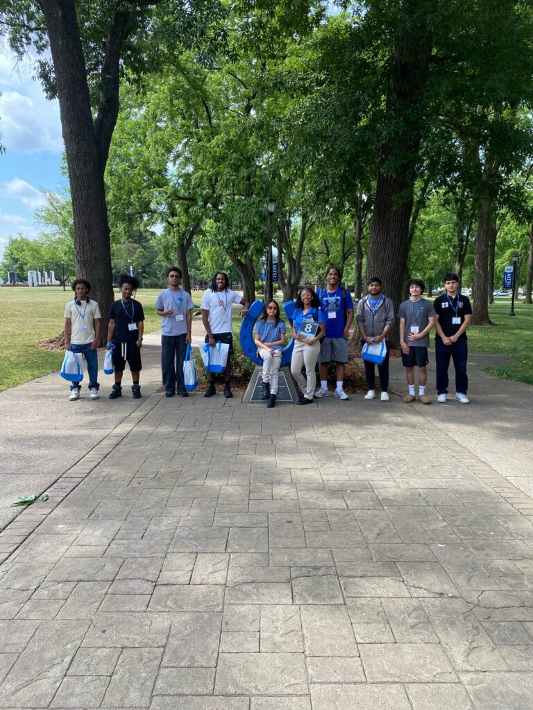 Students in Group 8 of orientation posing for a photo at the blue horseshoe at MTSU with their Student Orientation Assistant.