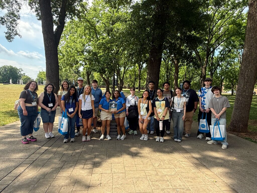 Students in Group 4 of orientation posing for a photo at the blue horseshoe at MTSU with their Student Orientation Assistants.