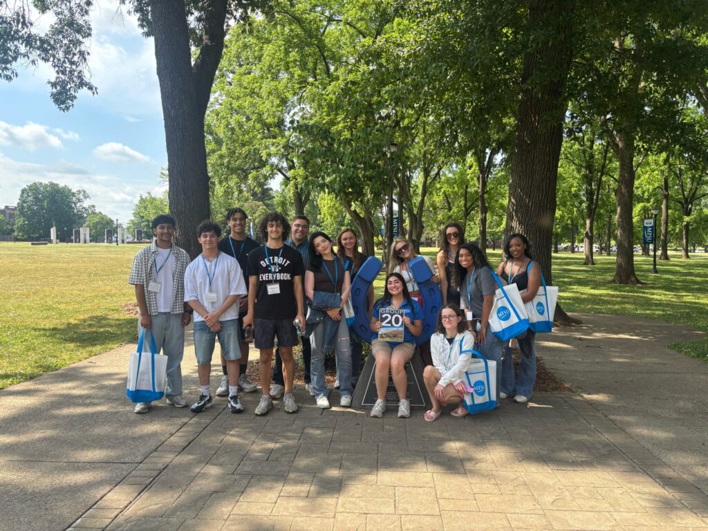 Students in Group 20 of orientation posing for a photo at the blue horseshoe at MTSU with their Student Orientation Assistant.