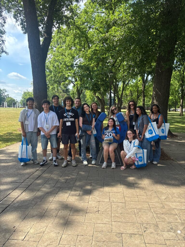 Students in Group 20 of orientation posing for a photo at the blue horseshoe at MTSU with their Student Orientation Assistant.
