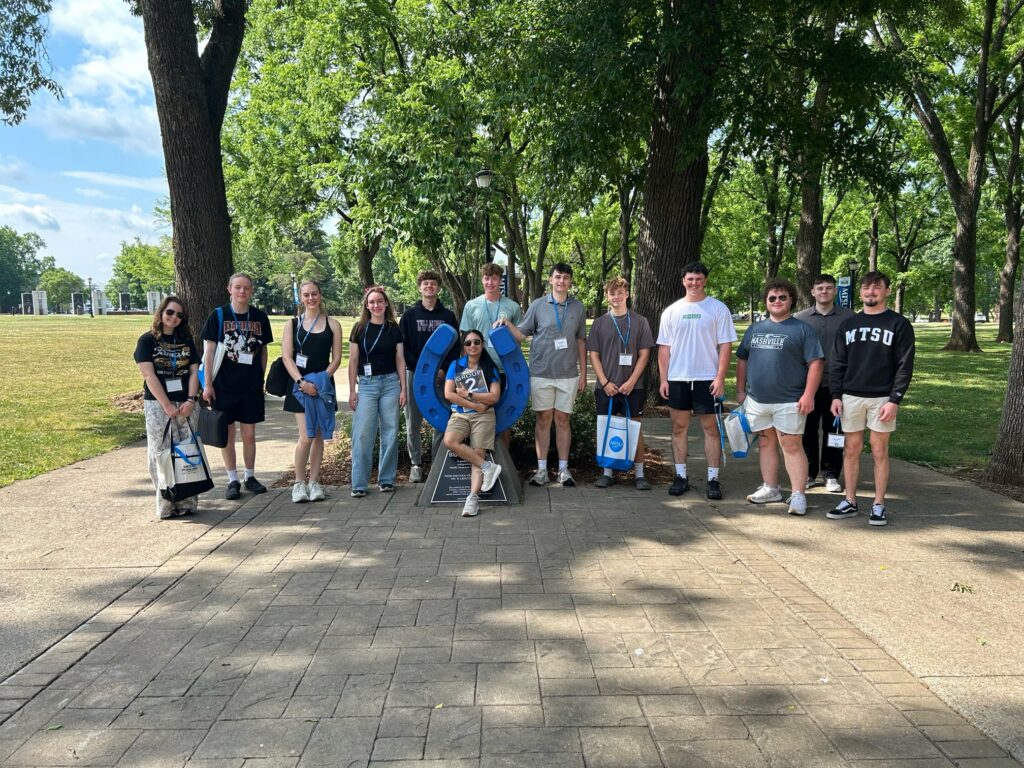 Students in Group 2 of orientation posing for a photo at the blue horseshoe at MTSU with their Student Orientation Assistant.
