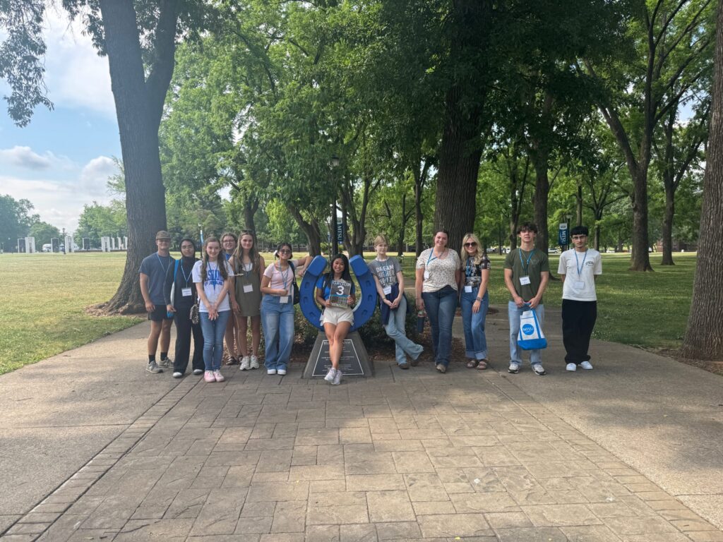 Students in Group 3 of orientation posing for a photo at the blue horseshoe at MTSU with their Student Orientation Assistant.