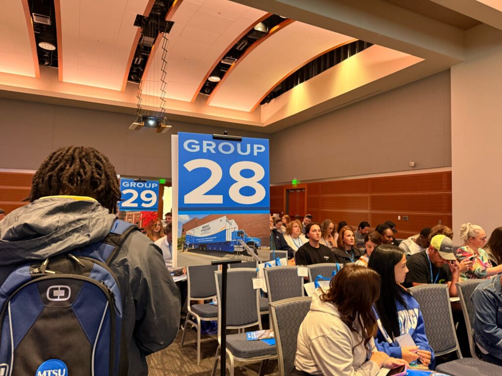 Students and guests attending New to Blue Orientation sitting in the Student Union near the Group 28 sign.