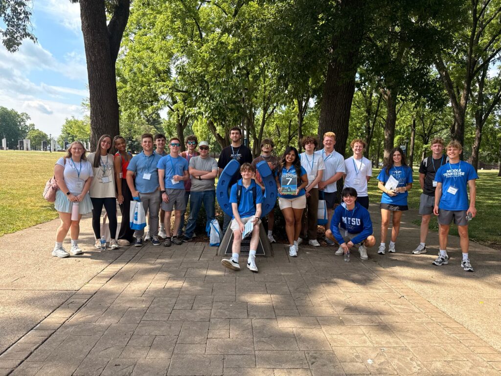 Students in Group 7 of orientation posing for a photo at the blue horseshoe at MTSU with their Student Orientation Assistant.