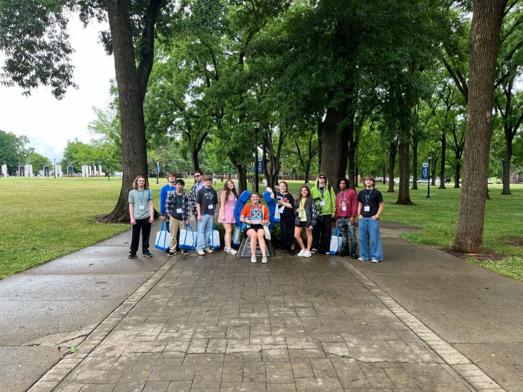 Students in Group 30 of orientation posing for a photo at the blue horseshoe at MTSU with their Student Orientation Assistant.