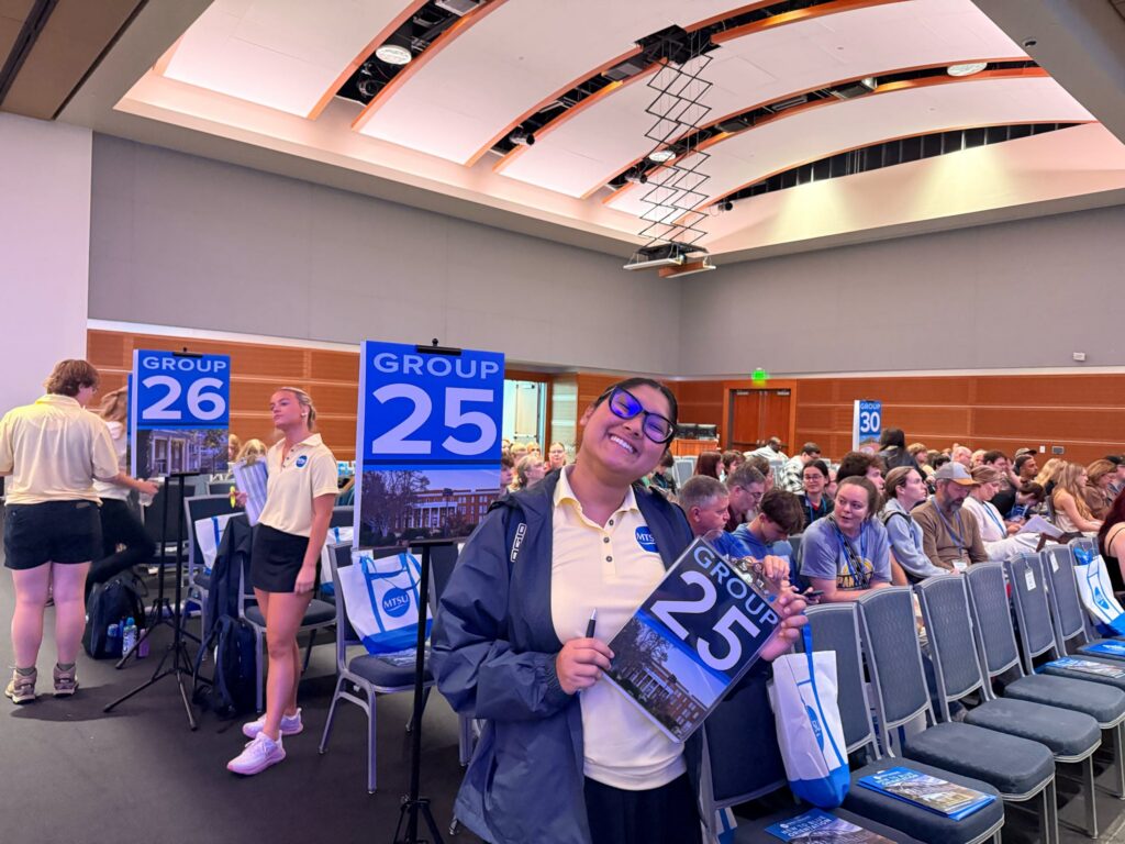 A Student Orientation Assistant posing for a photo in the Student Union Ballroom.