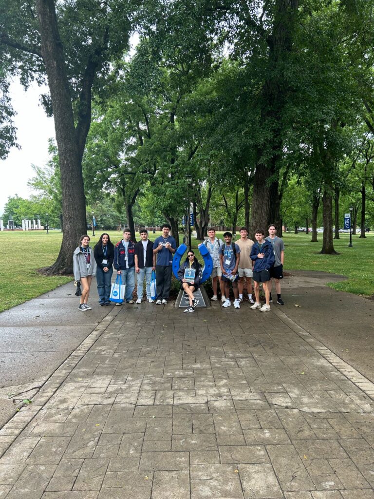 Students in Group 1 of orientation posing for a photo at the blue horseshoe at MTSU with their Student Orientation Assistant.