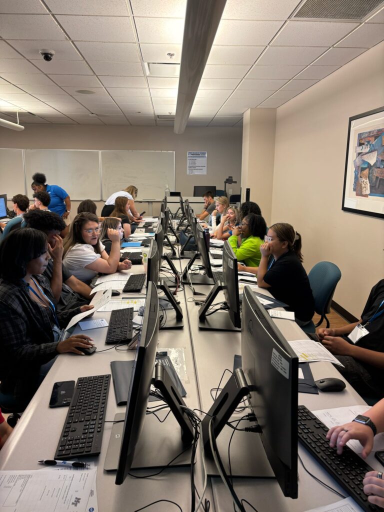 Students attending New to Blue Orientation sitting in a computer lab, registering for classes.