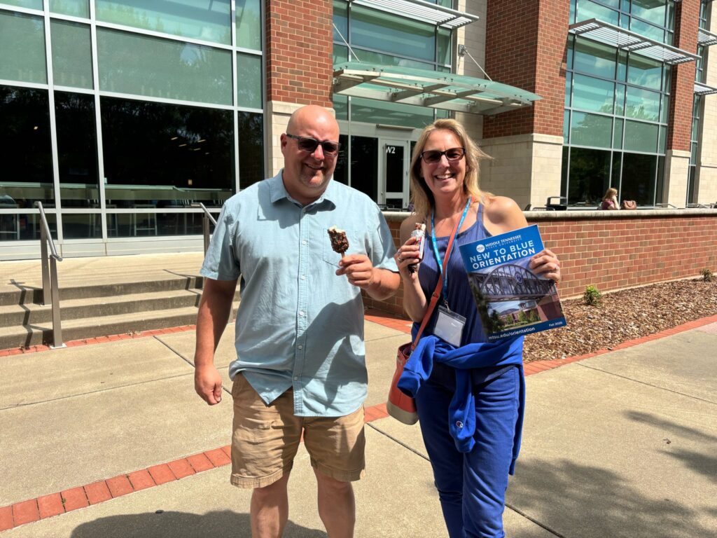 Guests at New to Blue Orientation posing outside the Student Union with ice cream.