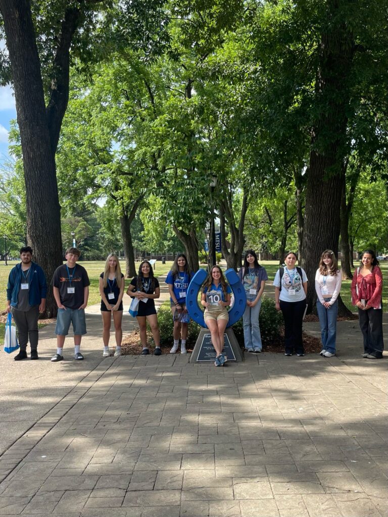 Students in Group 10 of orientation posing for a photo at the blue horseshoe at MTSU with their Student Orientation Assistant.