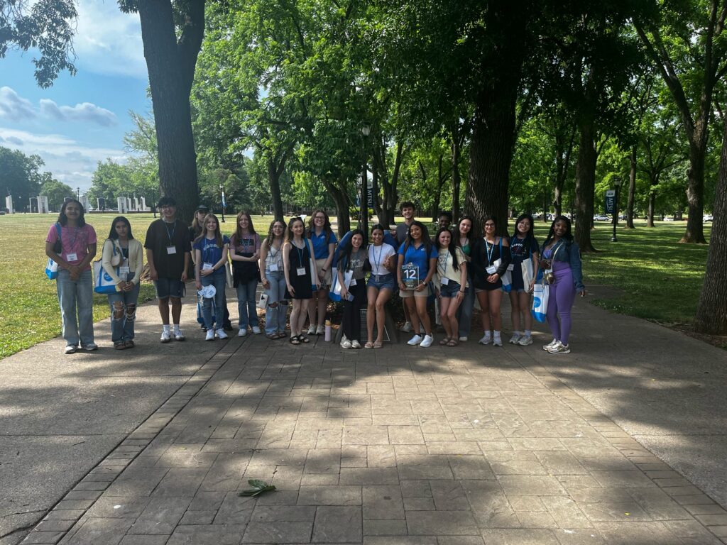 Students in Group 12 of orientation posing for a photo at the blue horseshoe at MTSU with their Student Orientation Assistant.