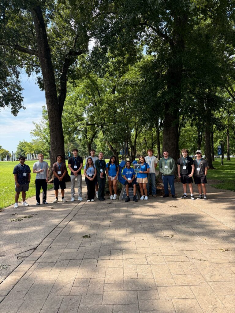 Students in Group 7 of orientation posing for a photo at the blue horseshoe at MTSU with their Student Orientation Assistant.