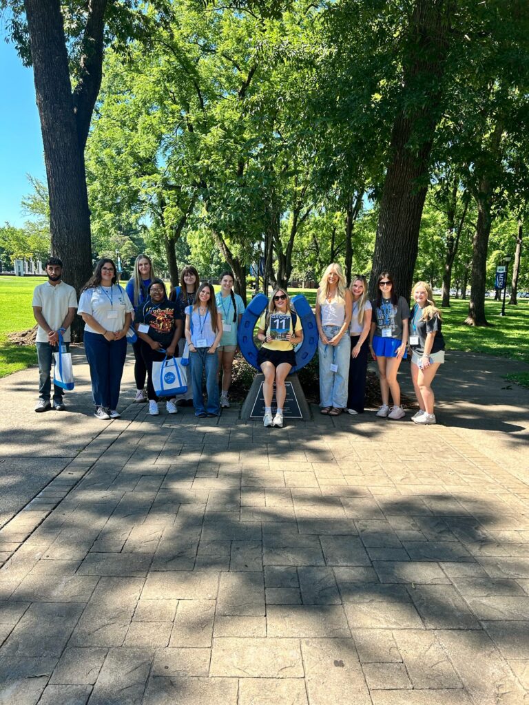 Students in Group 11 of orientation posing for a photo at the blue horseshoe at MTSU with their Student Orientation Assistants.